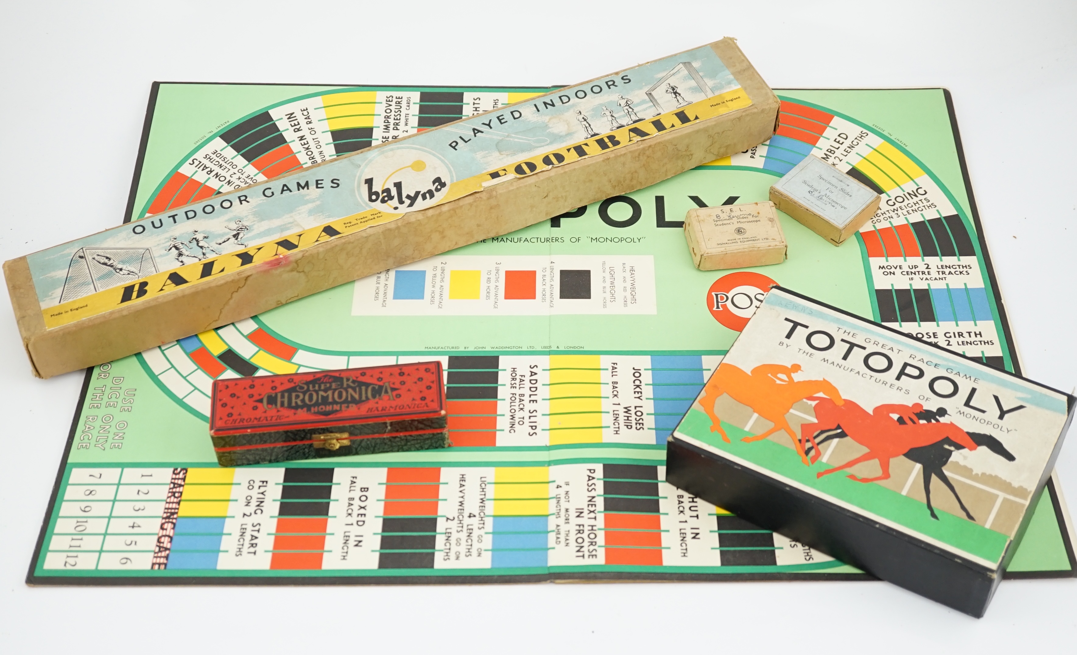 Eight 20th century to mid 20th century toys etc. including; an early boxed Subbuteo table soccer goal post set, a student microscope with slides, a boxed Balyna table football set, a Totopoly board game, a leatherworking